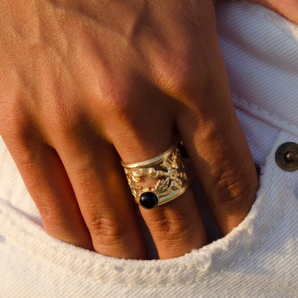 Main avec bague en argent ornée.