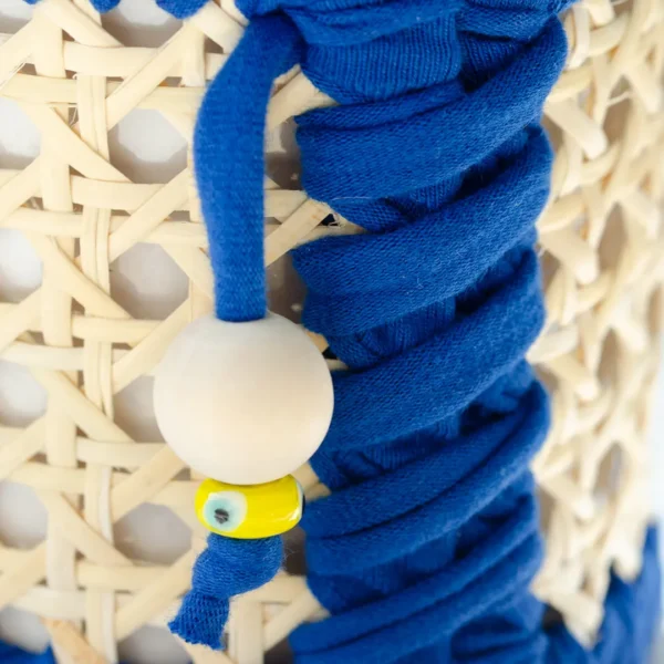 Gros plan sur la tresse et les perles de bois du Photophore en cannage de rotin, parfait pour une soirée romantique – une création Photyne.