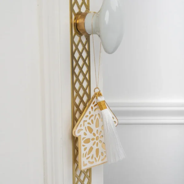 porte bonheur en forme de maison Estia par Photyne - métal dorée et émail blanc, pompon blanc, protection et chance pour votre foyer