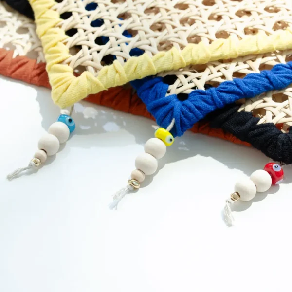 assortiement d'élégants sets de table en rotin tissé et réhaussé de petites perles de bois colorées, idéal pour recevoir avec naturel et style – une création Photyne.