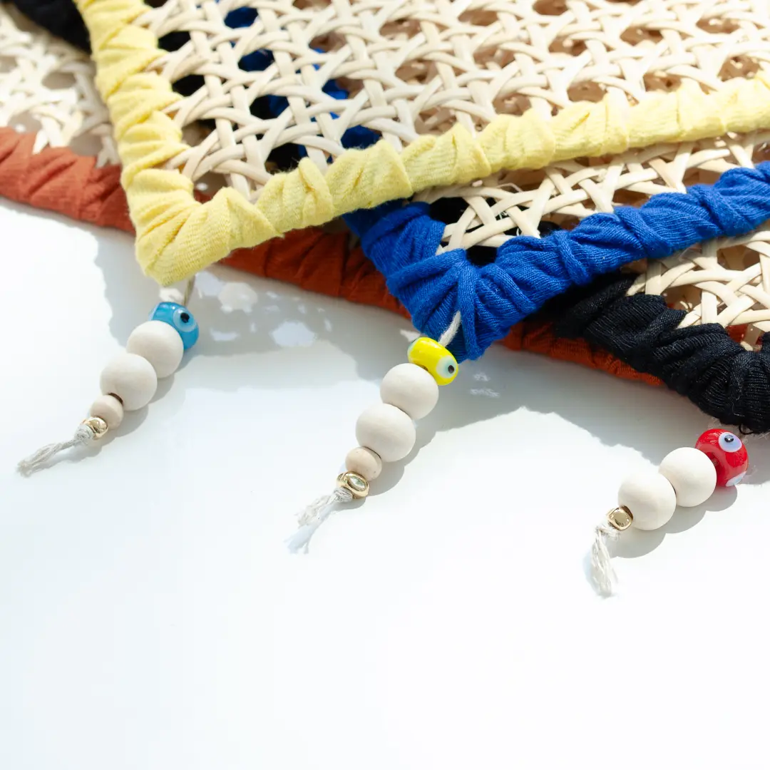 assortiement d'élégants sets de table en rotin tissé et réhaussé de petites perles de bois colorées, idéal pour recevoir avec naturel et style – une création Photyne.