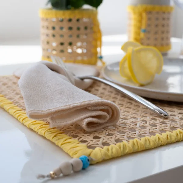 Set de table en rotin naturel, de couleur jaune soleil, style minimaliste, lumineux et sophistiqué – une création Photyne.