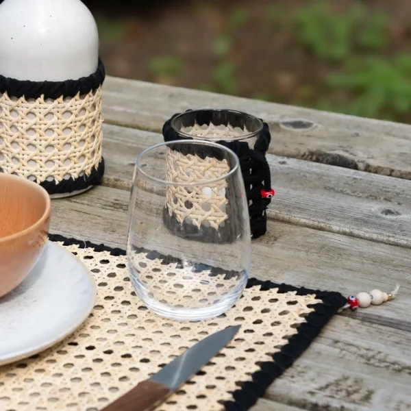 Set de table élégant en fibre de rotin, contour tressé noir et perles de bois, style méditerranéen et chaleureux – une création Photyne.