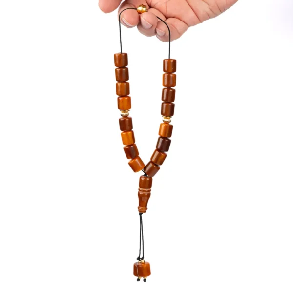Komboloi grec artisanal avec des perles cylindriques allant du roux au marron foncé, entrecoupées de perles dorées, monté sur un fil noir ultra résistant - Photyne