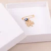 Broche porte chance pour bébé - dans sa boite cadeau -trèfle dorée et oeil bleu - un bijou grec - Photyne