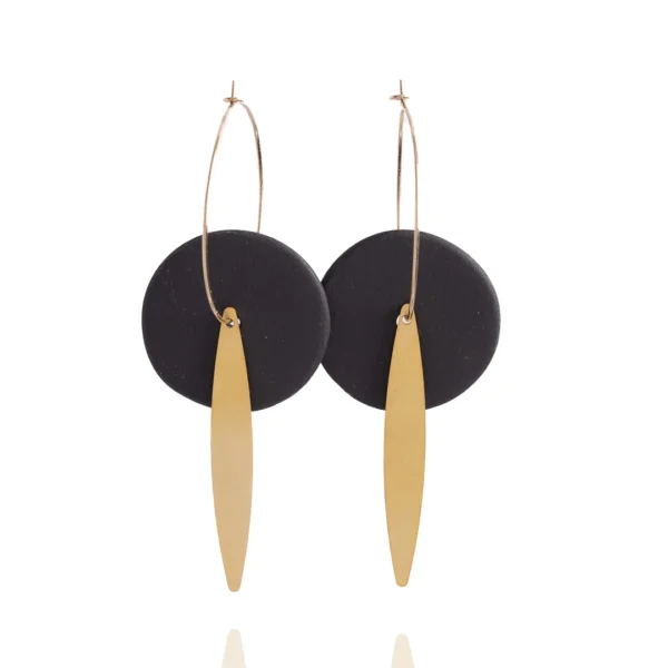 Gros plan sur les créoles Eléa - disques de grès noir mat et feuilles en laiton dorées à l'or fin - un bijou Photyne