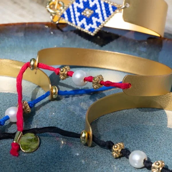 gros plan sur les bracelets Photyne - manchettes faites main dorées à l'or fin et cordons de soie multicolores