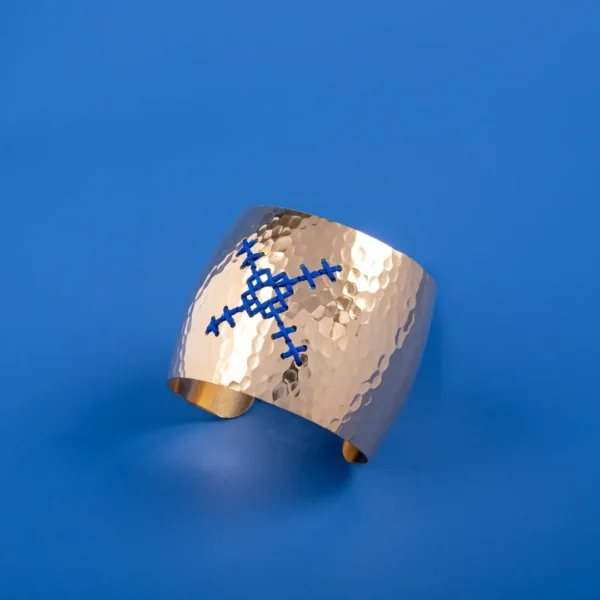 Plan serré sur une manchette crée par Photyne, en métal doré et broderie traditionnel grecque - modèle Kentima