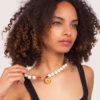 Collier en perles de lave blanche montées sur fil rouge, modèle Oia - un bijou Photyne