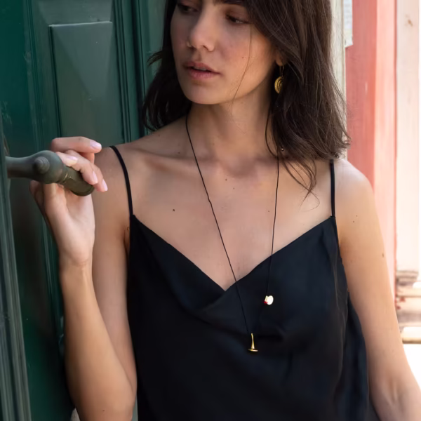 Jeune fille portant un sautoir composé d'un cordon noir et de breloque dorées en forme de toupie - modèle Svoura - Photyne