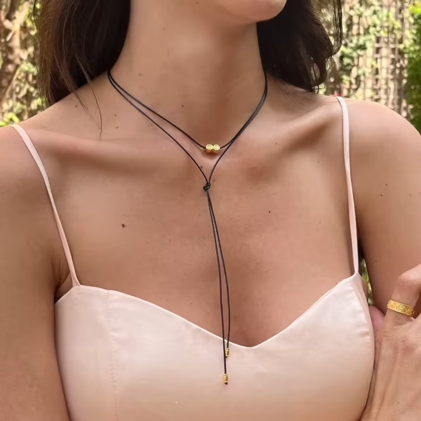 Ras du cou Ionos -collier Femme composé d'un lacet noir et d'une breloque dorée en forme de volute -Bijou Photyne