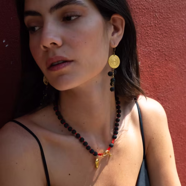 Collier élégant en pierre de lave, perles noires et breloque figure cycladique dorée, une création originale Photyne.