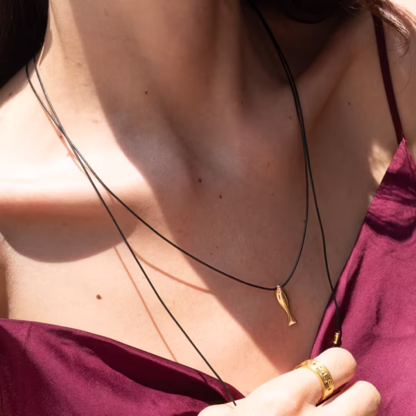 Sautoir composé d'un lacet noir et d'une breloque en forme de poisson doré - modèle Iktis - Photyne