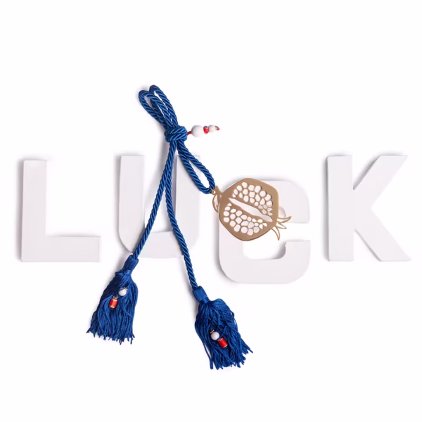 Objet déco porte-bonheur artisanal, grenade ajourée suspendue sur cordon bleu, symbole universel de chance et abondance, savoir faire artisanal Photyne.