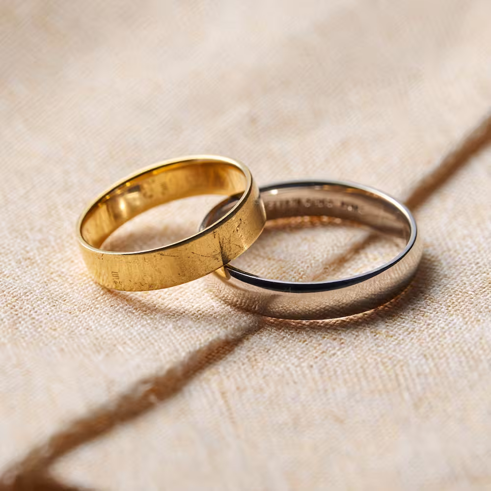 deux allainces or blanc et or jaune posée sur un tissu écru - photyne