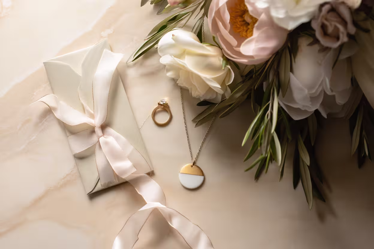 Collier en porcelaine blanche Photyne, bague en or et bouquet de fleurs fraîches sur tissu en lin beige, lumière naturelle méditerranéenne