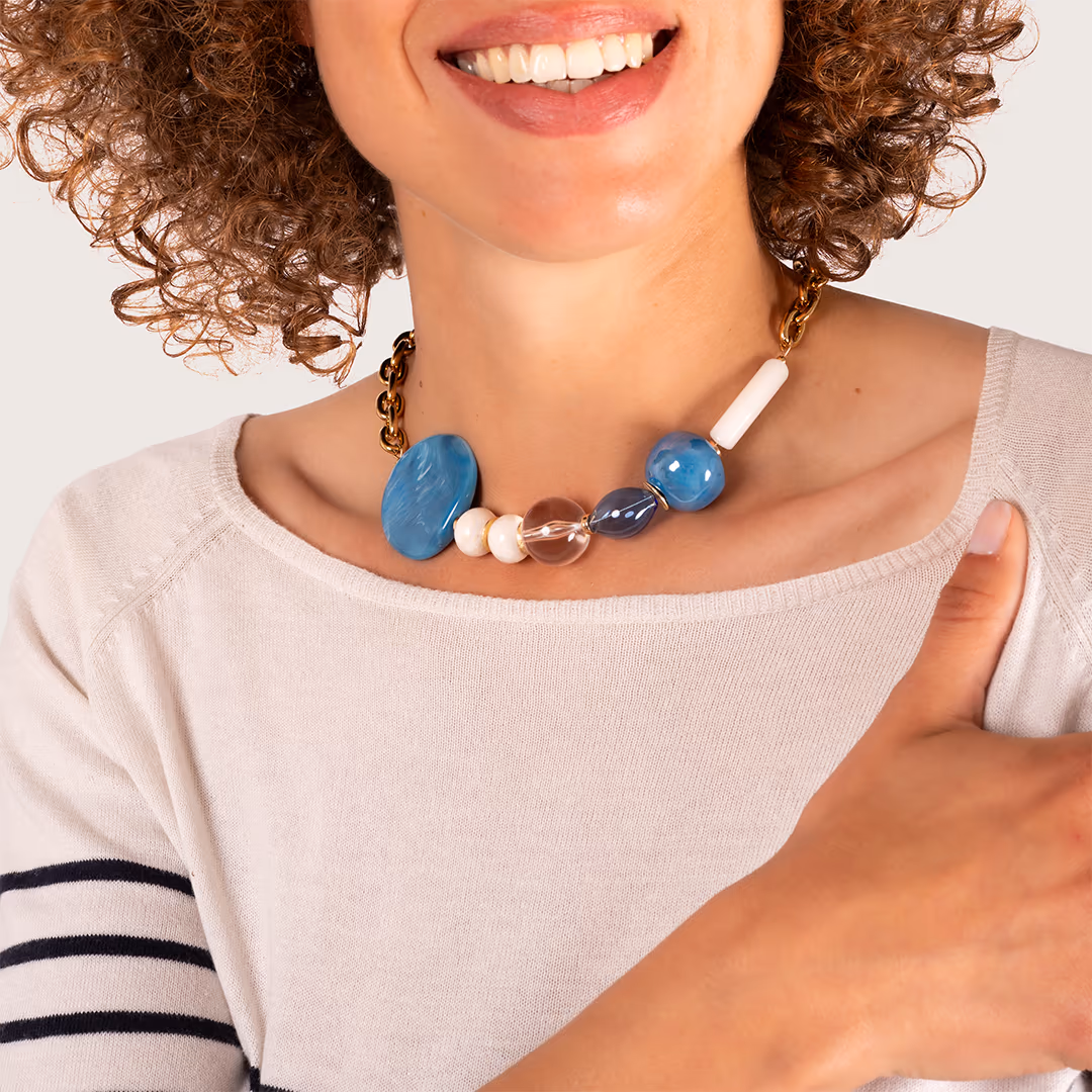 Collier de perles et pierres bleues porté par une femme