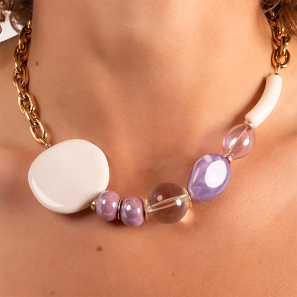 gros plan sur un ras du cou de perles colorées violet et blanc porté par une femme brune- modèle Kelana - un bijou unique Photyne