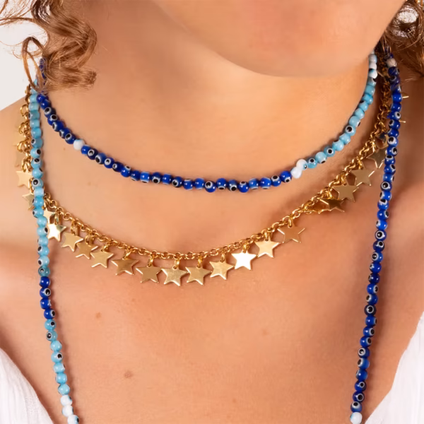 Colliers en perles bleues et chaîne dorée avec étoiles portés par une femme - modèle Asteria - Photyne