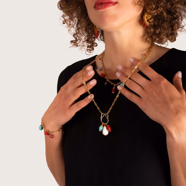 Sautoir et ras du cour en chaînes dorées avec pendentifs colorés porté par une femme - des bijoux Photyne