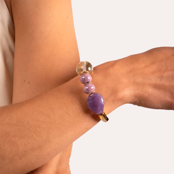 Bracelet chic avec grosses perles violettes et transparentes porté au poignet