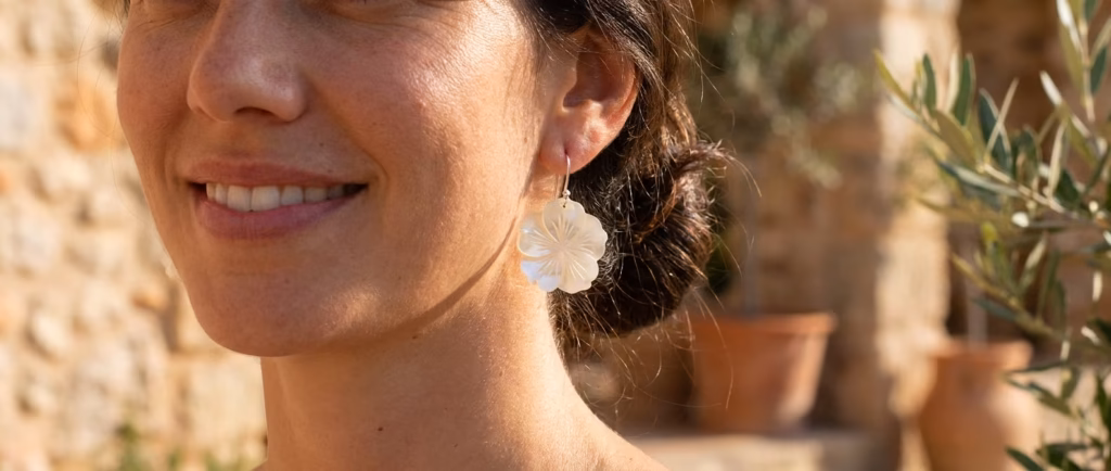 Boucles d'oreilles Vivi en nacre blanche portées pres du visage en lumiere naturelle
