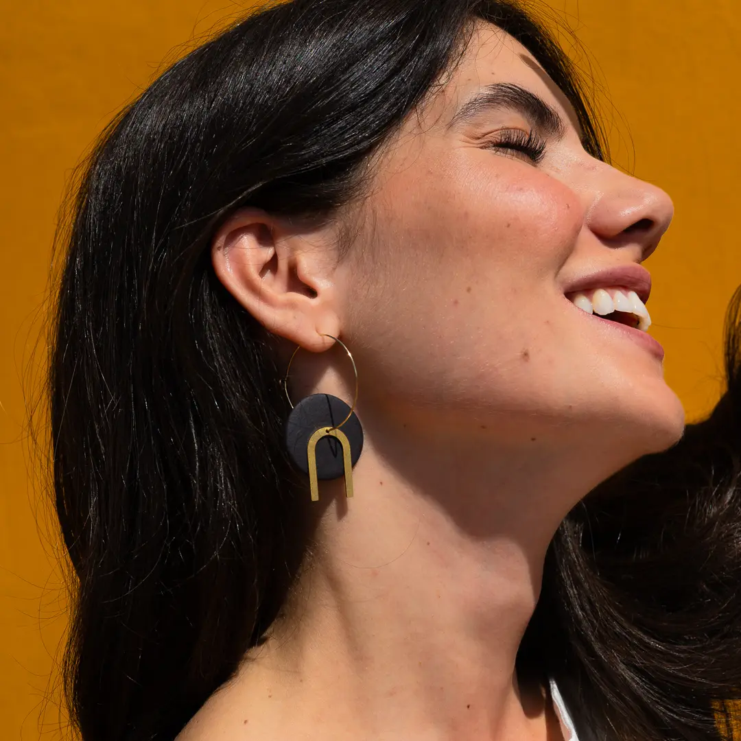 Boucles d'oreilles Mina en grès noir et or fin portées près du visage