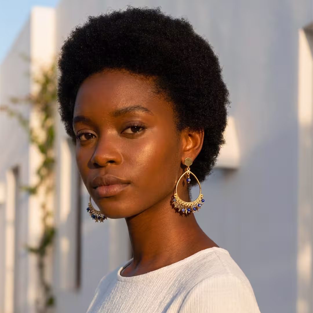 Jeune fille portant des boucles d'oreilles pendantes Eolia avec étoiles et yeux protecteurs bleus - Photyne