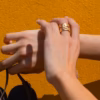 bague artisanale dorée finement ciselée et portée sur le doigt d'une femme - un bijou réalisé en France par Photyne.